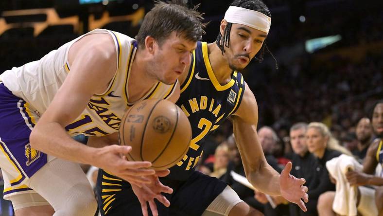 Mar 24, 2024; Los Angeles, California, USA;   Los Angeles Lakers guard Austin Reaves (15) and Indiana Pacers guard Andrew Nembhard (2) go for the ball in the second half at Crypto.com Arena. Mandatory Credit: Jayne Kamin-Oncea-USA TODAY Sports