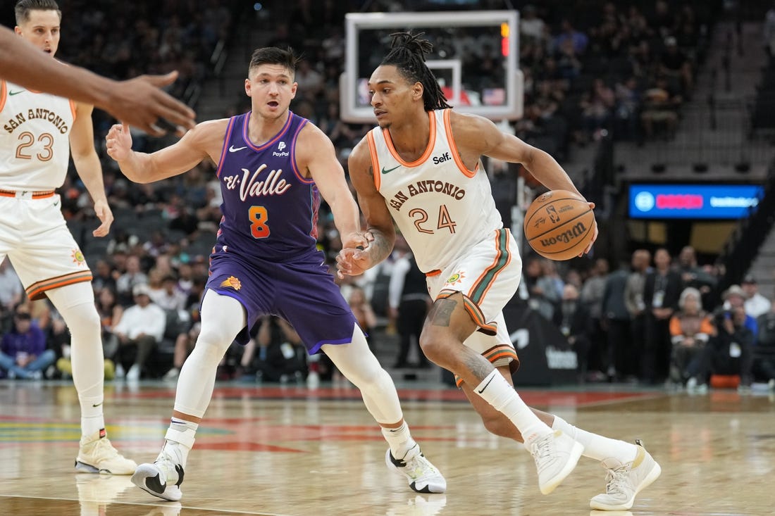 Mar 25, 2024; San Antonio, Texas, USA;  San Antonio Spurs guard Devin Vassell (24) drives past Phoenix Suns guard Grayson Allen (8) in the first half at Frost Bank Center. Mandatory Credit: Daniel Dunn-USA TODAY Sports