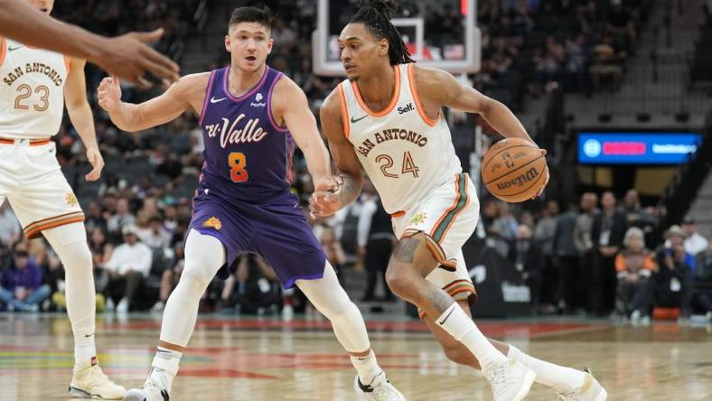 Mar 25, 2024; San Antonio, Texas, USA;  San Antonio Spurs guard Devin Vassell (24) drives past Phoenix Suns guard Grayson Allen (8) in the first half at Frost Bank Center. Mandatory Credit: Daniel Dunn-USA TODAY Sports