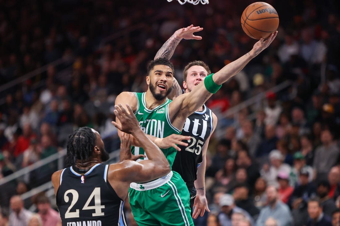 Mar 25, 2024; Atlanta, Georgia, USA; Boston Celtics forward Jayson Tatum (0) shoots past Atlanta Hawks forward Bruno Fernando (24) and guard Garrison Mathews (25) in the second quarter at State Farm Arena. Mandatory Credit: Brett Davis-USA TODAY Sports