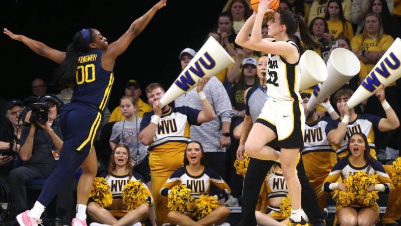 Iowa’s Caitlin Clark (22) shoots as West Virginia’s Jayla Hemingway (00) defends in a NCAA Tournament round of 32 game Monday, March 25, 2024 at Carver-Hawkeye Arena in Iowa City, Iowa.