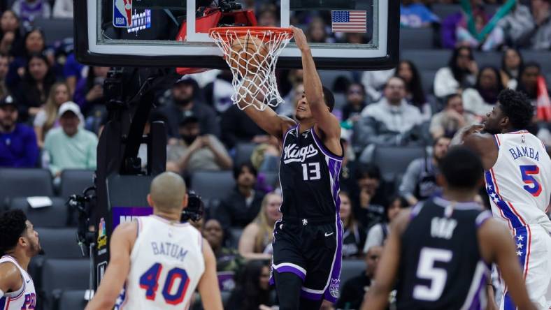 Mar 25, 2024; Sacramento, California, USA; Sacramento Kings forward Keegan Murray (13) dunks the ball against Philadelphia 76ers forward Nicolas Batum (40) during the first quarter at Golden 1 Center. Mandatory Credit: Sergio Estrada-USA TODAY Sports