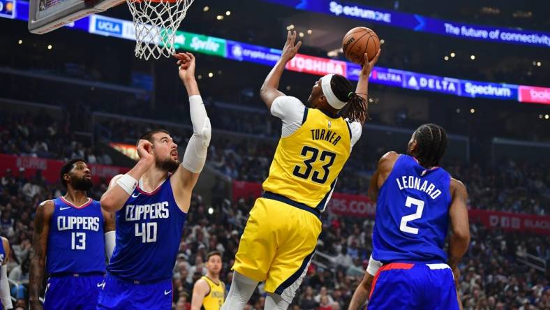 Mar 25, 2024; Los Angeles, California, USA; Indiana Pacers center Myles Turner (33) shoots against Los Angeles Clippers center Ivica Zubac (40) and forward Kawhi Leonard (2) during the first half at Crypto.com Arena. Mandatory Credit: Gary A. Vasquez-USA TODAY Sports