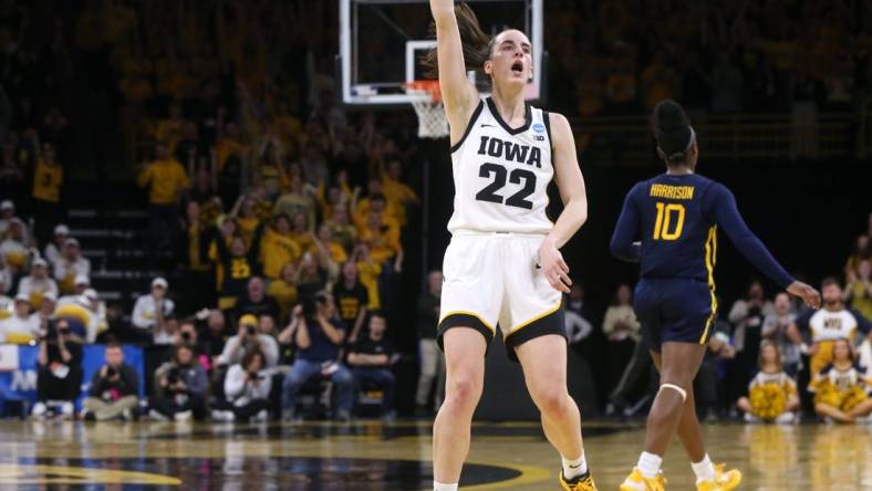 Iowa’s Caitlin Clark (22) holds a pose as she celebrates a made 3-point basket against West Virginia in a NCAA Tournament round of 32 game Monday, March 25, 2024 at Carver-Hawkeye Arena.