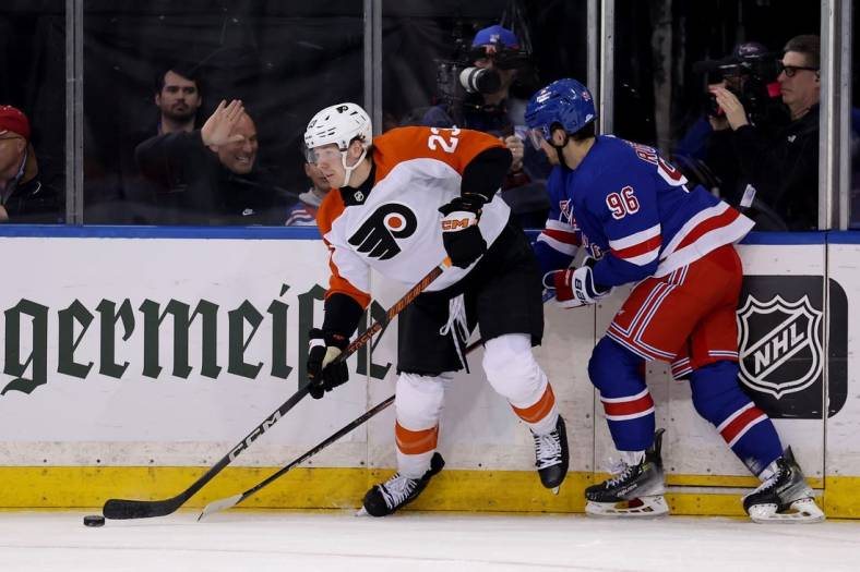 Mar 26, 2024; New York, New York, USA; Philadelphia Flyers defenseman Ronnie Attard (23) looks to pass the puck against New York Rangers center Jack Roslovic (96) during the first period at Madison Square Garden. Mandatory Credit: Brad Penner-USA TODAY Sports