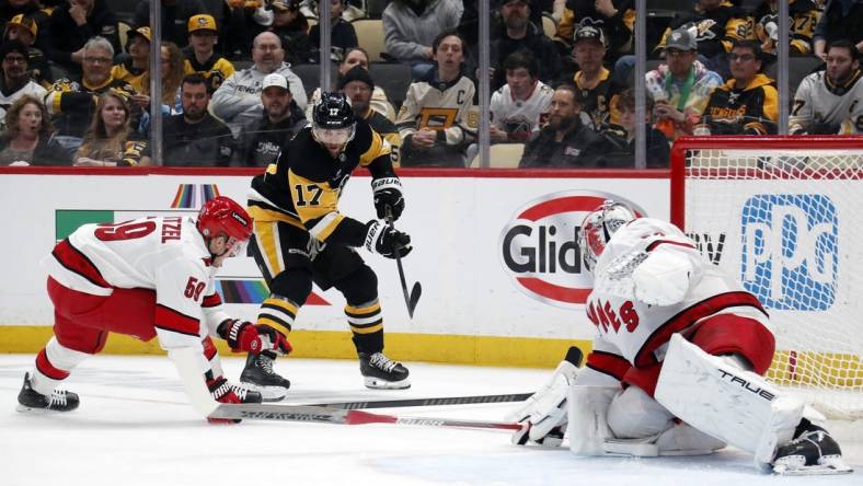 Mar 26, 2024; Pittsburgh, Pennsylvania, USA; Carolina Hurricanes left wing Jake Guentzel (59) and goaltender Pyotr Kochetkov (52) defend Pittsburgh Penguins right wing Bryan Rust (17) during the first period at PPG Paints Arena. Mandatory Credit: Charles LeClaire-USA TODAY Sports