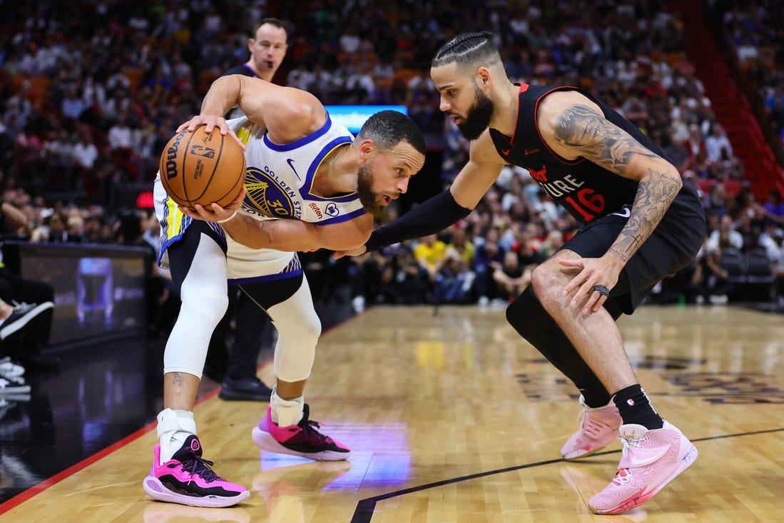 Mar 26, 2024; Miami, Florida, USA; Golden State Warriors guard Stephen Curry (30) protects the basketball from Miami Heat forward Caleb Martin (16) during the first quarter at Kaseya Center. Mandatory Credit: Sam Navarro-USA TODAY Sports