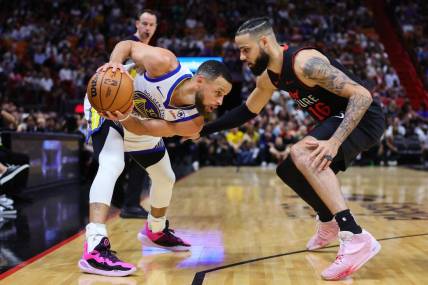 Mar 26, 2024; Miami, Florida, USA; Golden State Warriors guard Stephen Curry (30) protects the basketball from Miami Heat forward Caleb Martin (16) during the first quarter at Kaseya Center. Mandatory Credit: Sam Navarro-USA TODAY Sports