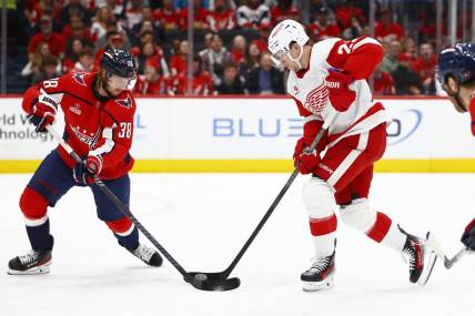 Mar 26, 2024; Washington, District of Columbia, USA; Detroit Red Wings left wing Lucas Raymond (23) battles for the puck with Washington Capitals defenseman Rasmus Sandin (38) during the second period at Capital One Arena. Mandatory Credit: Amber Searls-USA TODAY Sports