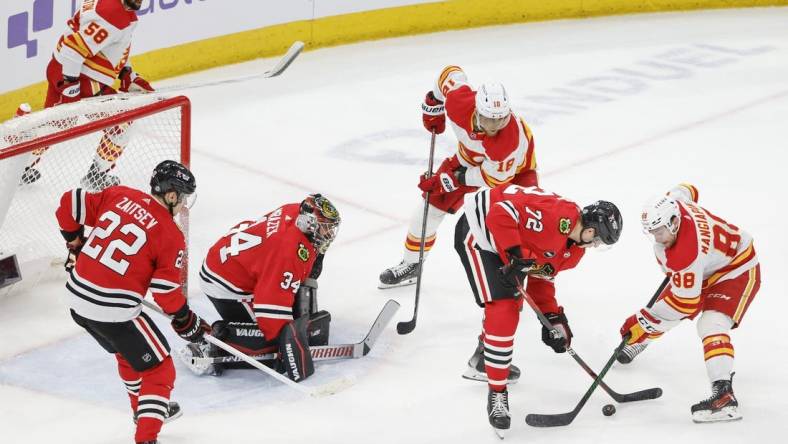 Mar 26, 2024; Chicago, Illinois, USA; Chicago Blackhawks defenseman Alex Vlasic (72) battles for the puck with Calgary Flames left wing Andrew Mangiapane (88) during the second period at United Center. Mandatory Credit: Kamil Krzaczynski-USA TODAY Sports