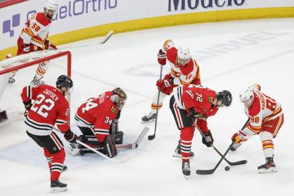 Mar 26, 2024; Chicago, Illinois, USA; Chicago Blackhawks defenseman Alex Vlasic (72) battles for the puck with Calgary Flames left wing Andrew Mangiapane (88) during the second period at United Center. Mandatory Credit: Kamil Krzaczynski-USA TODAY Sports