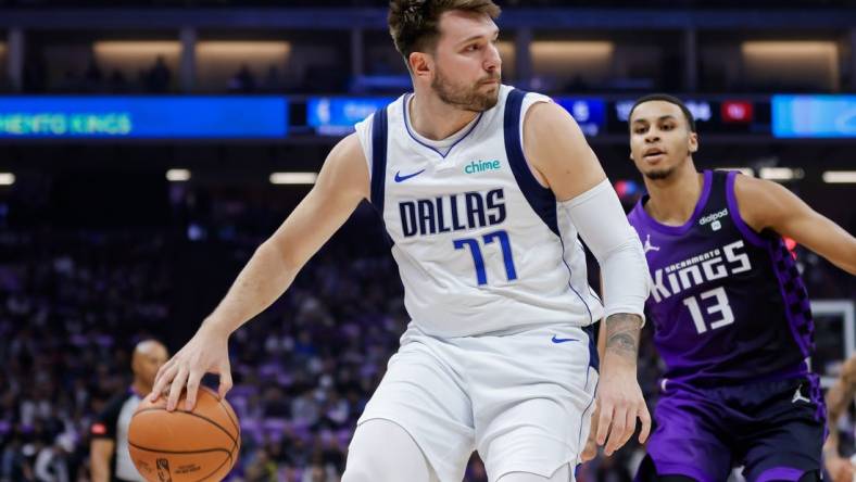 Mar 26, 2024; Sacramento, California, USA; Dallas Mavericks guard Luka Doncic (77) passes the ball against Sacramento Kings forward Keegan Murray (13) during the first quarter at Golden 1 Center. Mandatory Credit: Sergio Estrada-USA TODAY Sports