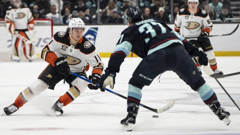 Mar 26, 2024; Seattle, Washington, USA; Anaheim Ducks forward Trevor Zegras (11) skates against Seattle Kraken forward Yanni Gourde (37) during the first period at Climate Pledge Arena. Mandatory Credit: Stephen Brashear-USA TODAY Sports