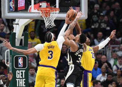 Mar 26, 2024; Milwaukee, Wisconsin, USA; Milwaukee Bucks forward Giannis Antetokounmpo (34) puts up a shot against Los Angeles Lakers forward Anthony Davis (3) and Los Angeles Lakers forward Rui Hachimura (28) in the second overtime at Fiserv Forum. Mandatory Credit: Michael McLoone-USA TODAY Sports