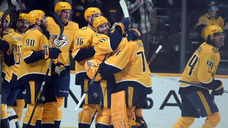 Mar 26, 2024; Nashville, Tennessee, USA; Nashville Predators left wing Jason Zucker (16) celebrates with goaltender Juuse Saros (74) after an overtime win against the Vegas Golden Knights at Bridgestone Arena. Mandatory Credit: Christopher Hanewinckel-USA TODAY Sports