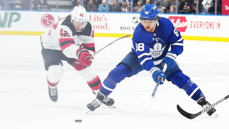 Mar 26, 2024; Toronto, Ontario, CAN; Toronto Maple Leafs right wing William Nylander (88) battles for the puck with New Jersey Devils defenseman Brendan Smith (2) during the third period at Scotiabank Arena. Mandatory Credit: Nick Turchiaro-USA TODAY Sports