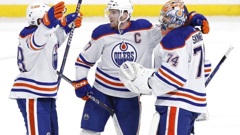 Mar 26, 2024; Winnipeg, Manitoba, CAN; Edmonton Oilers right wing Connor Brown (28), Edmonton Oilers center Connor McDavid (97) and Edmonton Oilers goaltender Stuart Skinner (74) celebrate their overtime victory against the Winnipeg Jets at Canada Life Centre. Mandatory Credit: James Carey Lauder-USA TODAY Sports