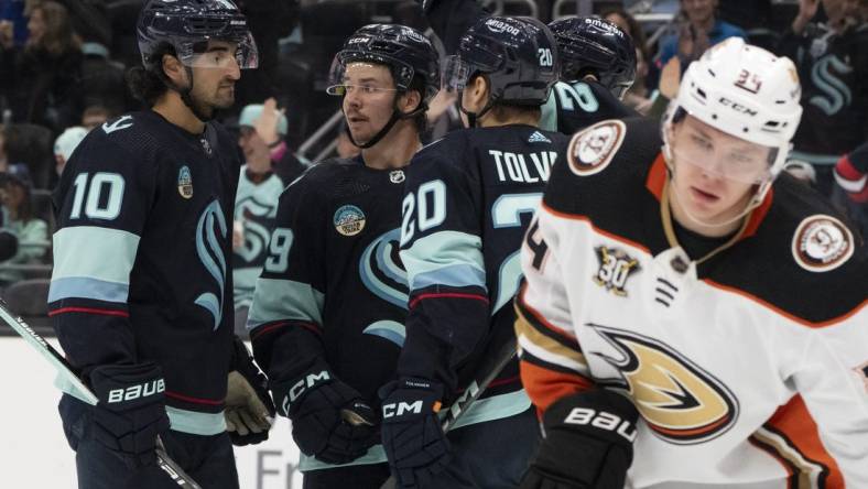 Mar 26, 2024; Seattle, Washington, USA; sSeattle Kraken players icnlduing forward Matty Beniers (10), forward Logan Morrison (59), second from left, and forward Eeli Tolvanen (20) celebrate a goald during the second period against the Anaheim Ducks gat Climate Pledge Arena. Mandatory Credit: Stephen Brashear-USA TODAY Sports