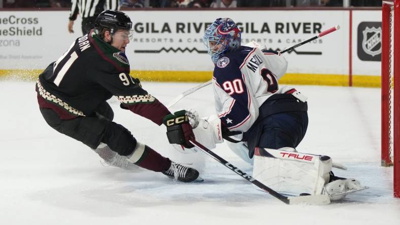 Mar 26, 2024; Tempe, Arizona, USA; Columbus Blue Jackets goaltender Elvis Merzlikins (90) makes the save on Arizona Coyotes right wing Josh Doan (91) in the second period at Mullett Arena. Mandatory Credit: Rick Scuteri-USA TODAY Sports