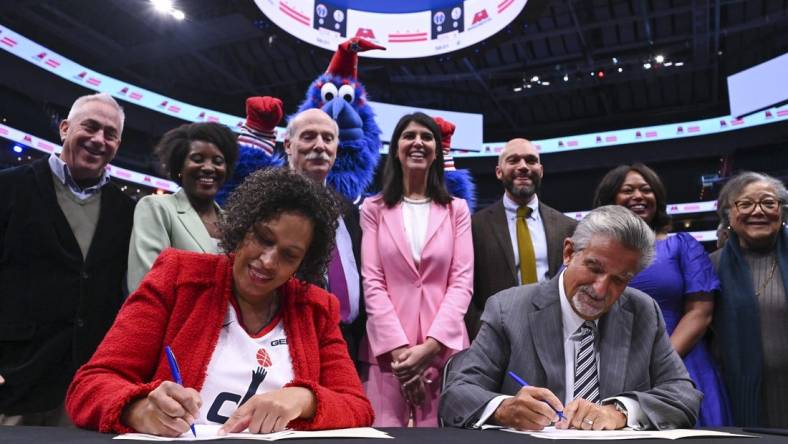 Mar 27, 2024; Washington, District of Columbia, USA;  Washington DC mayor Muriel Bowser  and Monumental Sports & Entertainment CEO Ted Leonsis sign an agreement on the court before the game between the Brooklyn Nets and the Washington Wizards at Capital One Arena. Mandatory Credit: Tommy Gilligan-USA TODAY Sports