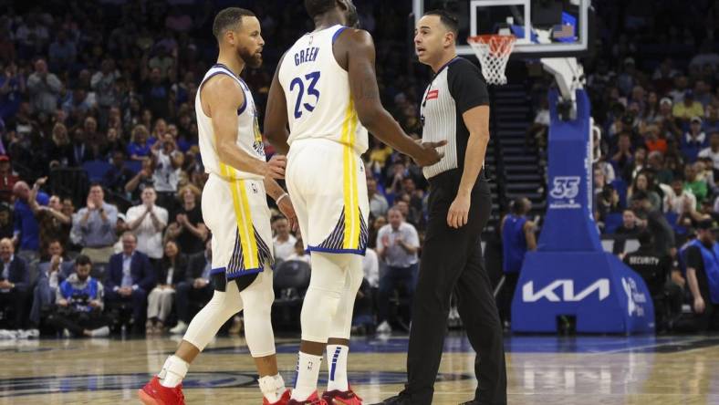 Mar 27, 2024; Orlando, Florida, USA;  Golden State Warriors forward Draymond Green (23) talks to referee Ray Acosta (54) after receiving a foul in the first quarter at the Kia Center. Mandatory Credit: Nathan Ray Seebeck-USA TODAY Sports