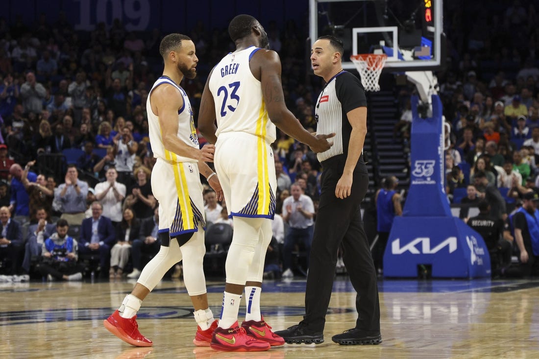 Mar 27, 2024; Orlando, Florida, USA;  Golden State Warriors forward Draymond Green (23) talks to referee Ray Acosta (54) after receiving a foul in the first quarter at the Kia Center. Mandatory Credit: Nathan Ray Seebeck-USA TODAY Sports