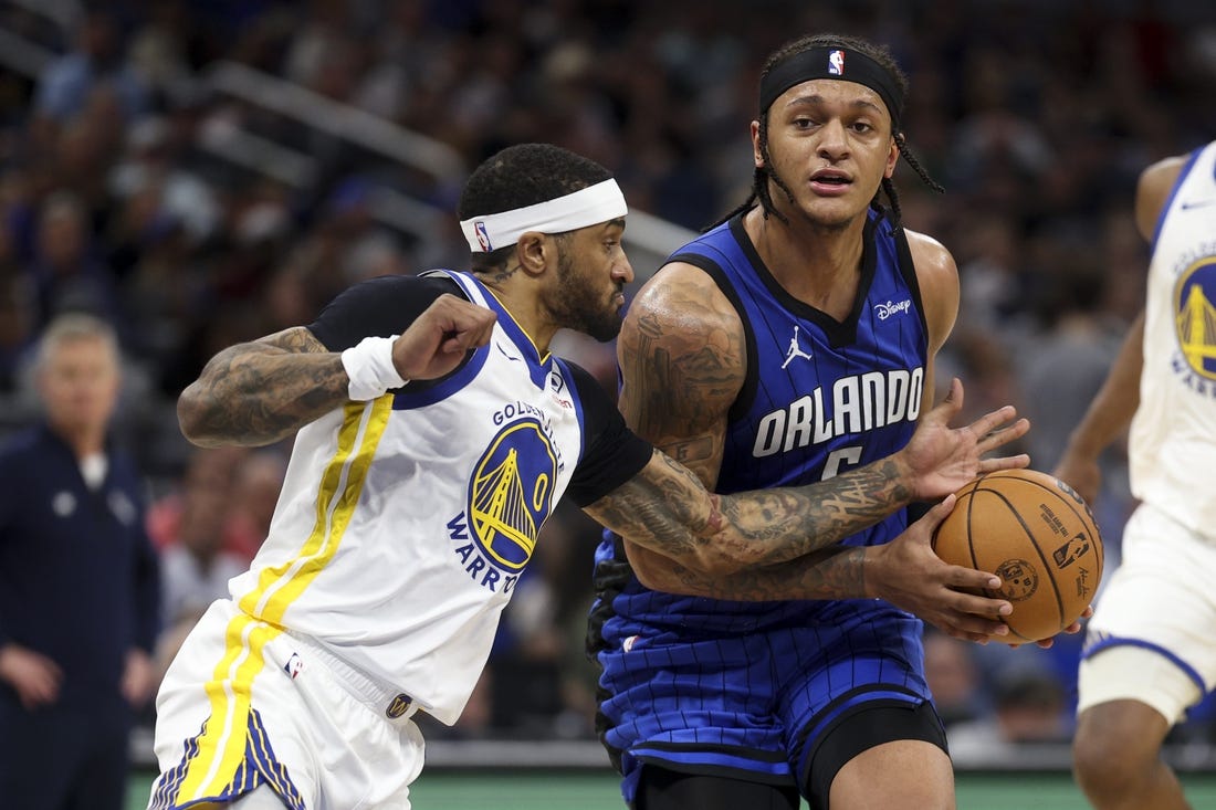 Mar 27, 2024; Orlando, Florida, USA;  Orlando Magic forward Paolo Banchero (5) drives the ball past Golden State Warriors guard Gary Payton II (0) in the second quarter at the Kia Center. Mandatory Credit: Nathan Ray Seebeck-USA TODAY Sports