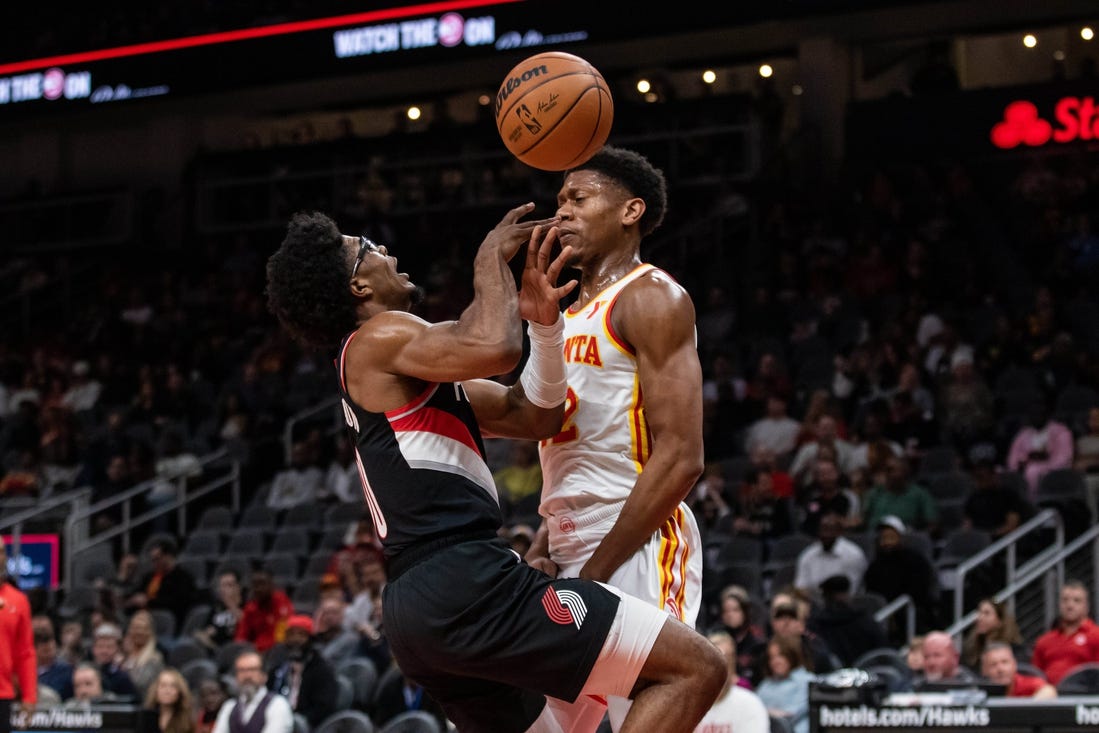 Mar 27, 2024; Atlanta, Georgia, USA; Atlanta Hawks forward De'Andre Hunter (12) defends the basket against Portland Trail Blazers guard Scoot Henderson (00) during the first quarter at State Farm Arena. Mandatory Credit: Jordan Godfree-USA TODAY Sports