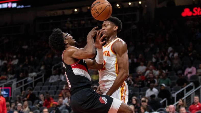 Mar 27, 2024; Atlanta, Georgia, USA; Atlanta Hawks forward De'Andre Hunter (12) defends the basket against Portland Trail Blazers guard Scoot Henderson (00) during the first quarter at State Farm Arena. Mandatory Credit: Jordan Godfree-USA TODAY Sports