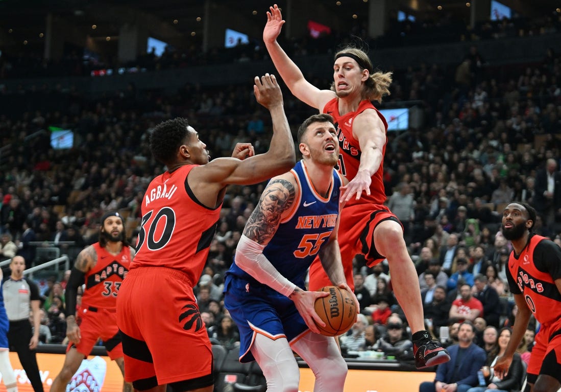 Mar 27, 2024; Toronto, Ontario, CAN; New York Knicks center Isaiah Hartenstein (55) drives against Toronto Raptors forward Kelly Olynyk (41) and guard Ochai Agbaji (30) in the first half at Scotiabank Arena. Mandatory Credit: Dan Hamilton-USA TODAY Sports