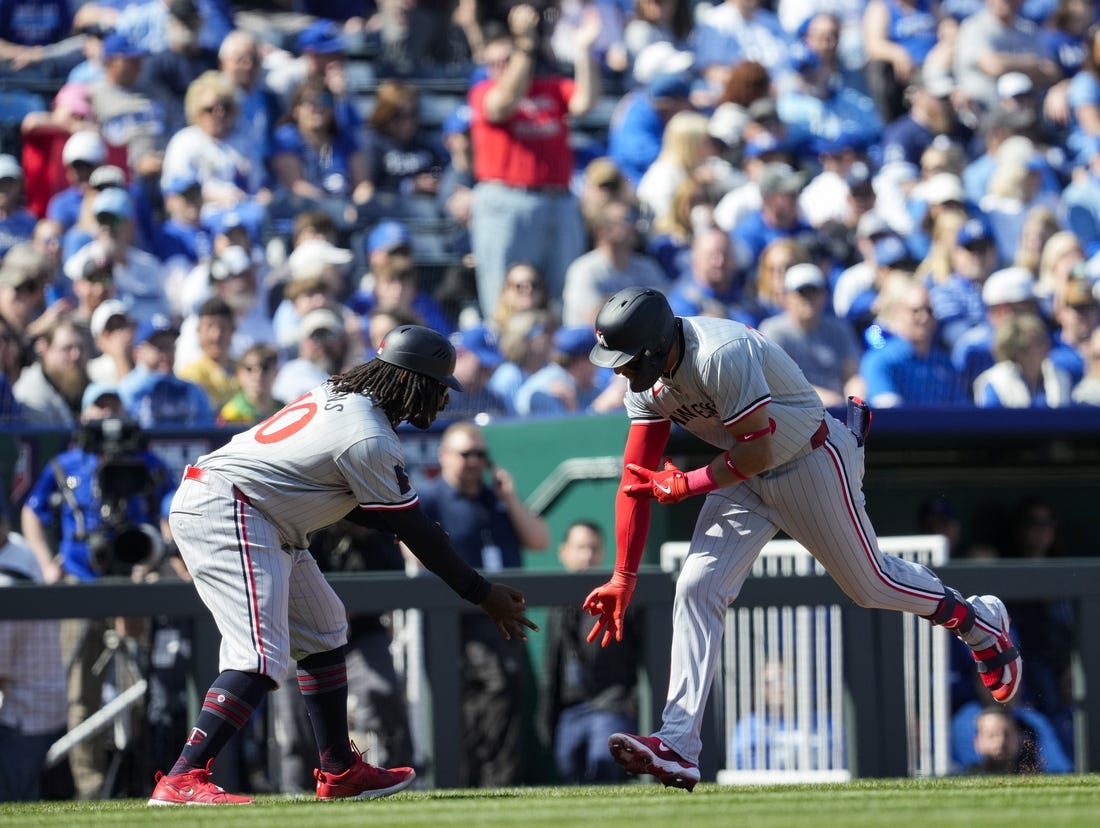 Mar 28, 2024; Kansas City, Missouri, USA; Minnesota Twins third baseman Royce Lewis (23) celebrates with third base coach Tommy Watkins after hitting a home run during the first inning against the Kansas City Royals at Kauffman Stadium. Mandatory Credit: Jay Biggerstaff-USA TODAY Sports