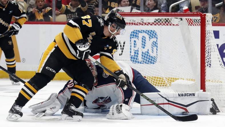 Mar 28, 2024; Pittsburgh, Pennsylvania, USA; Columbus Blue Jackets goaltender Daniil Tarasov (40) makes a pad save against Pittsburgh Penguins center Sidney Crosby (87) during the first period at PPG Paints Arena. Mandatory Credit: Charles LeClaire-USA TODAY Sports