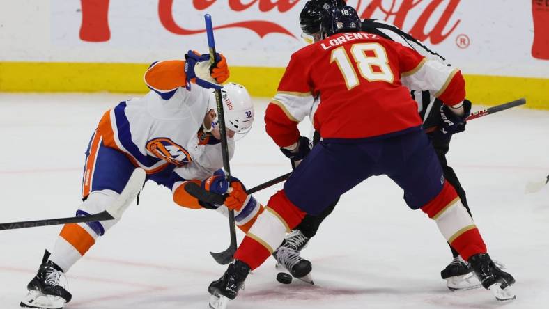 Mar 28, 2024; Sunrise, Florida, USA; New York Islanders center Kyle MacLean (32) and Florida Panthers center Steven Lorentz (18) face-off during the first period at Amerant Bank Arena. Mandatory Credit: Sam Navarro-USA TODAY Sports