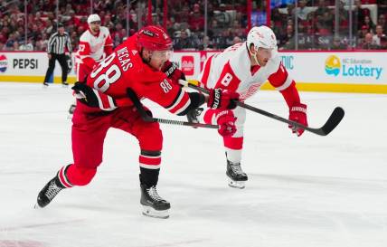 Mar 28, 2024; Raleigh, North Carolina, USA;  Carolina Hurricanes center Martin Necas (88) gets the shot past Detroit Red Wings defenseman Ben Chiarot (8) during the second period at PNC Arena. Mandatory Credit: James Guillory-USA TODAY Sports