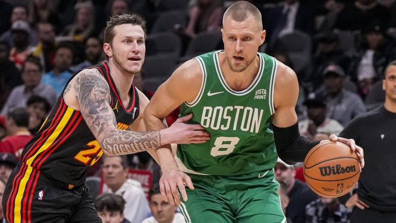 Mar 28, 2024; Atlanta, Georgia, USA; Boston Celtics center Kristaps Porzingis (8) dribbles against Atlanta Hawks guard Garrison Mathews (25) during the first half at State Farm Arena. Mandatory Credit: Dale Zanine-USA TODAY Sports