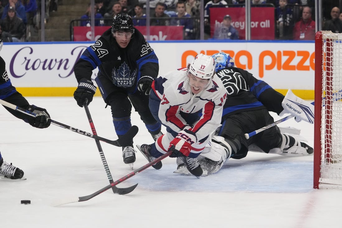 Mar 28, 2024; Toronto, Ontario, CAN; Toronto Maple Leafs forward Connor Dewar (24) knocks Washington Capitals forward Dylan Strome (17) off of the puck as he breaks in on Toronto Maple Leafs goaltender Joseph Woll (60) during the second period at Scotiabank Arena. Mandatory Credit: John E. Sokolowski-USA TODAY Sports