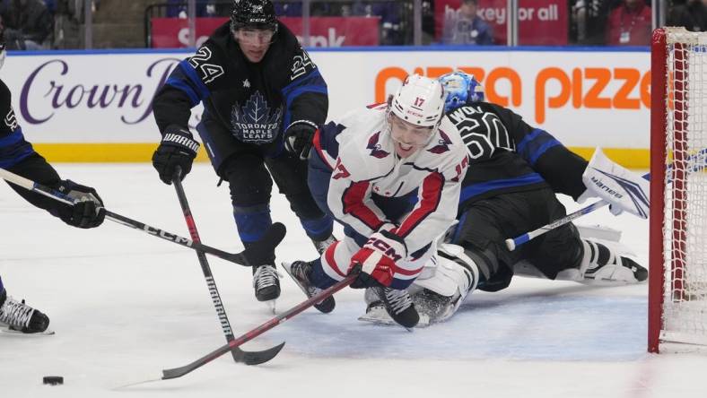 Mar 28, 2024; Toronto, Ontario, CAN; Toronto Maple Leafs forward Connor Dewar (24) knocks Washington Capitals forward Dylan Strome (17) off of the puck as he breaks in on Toronto Maple Leafs goaltender Joseph Woll (60) during the second period at Scotiabank Arena. Mandatory Credit: John E. Sokolowski-USA TODAY Sports