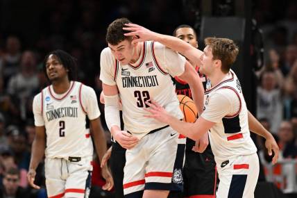 Mar 28, 2024; Boston, MA, USA; Connecticut Huskies guard Cam Spencer (12) reacts with center Donovan Clingan (32) in the semifinals of the East Regional of the 2024 NCAA Tournament at TD Garden. Mandatory Credit: Brian Fluharty-USA TODAY Sports