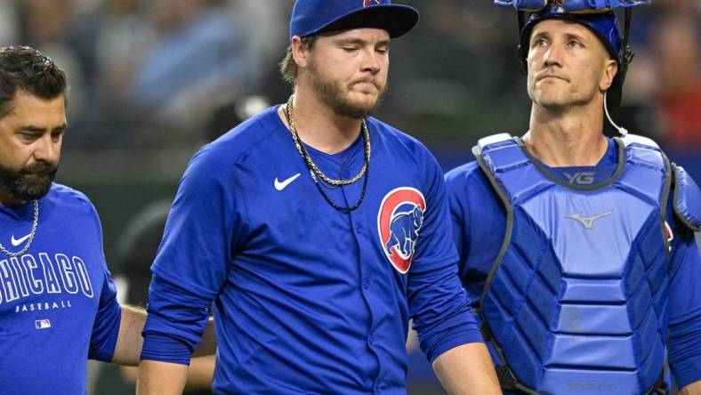 Mar 31, 2024; Arlington, Texas, USA; Chicago Cubs starting pitcher Justin Steele (35) and catcher Yan Gomes (15) walk off the field after Steele suffers an injury during the fifth inning against the Texas Rangers at Globe Life Field. Mandatory Credit: Jerome Miron-USA TODAY Sports