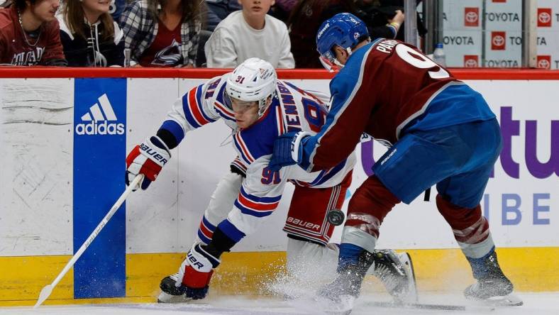 Mar 28, 2024; Denver, Colorado, USA; New York Rangers center Alex Wennberg (91) and Colorado Avalanche left wing Zach Parise (9) battle for the puck in the first period at Ball Arena. Mandatory Credit: Isaiah J. Downing-USA TODAY Sports