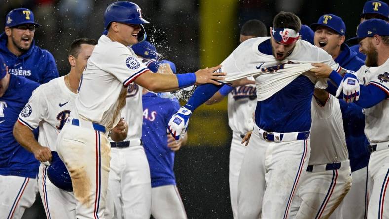 Mar 31, 2024; Arlington, Texas, USA; Texas Rangers catcher Jonah Heim (28) and third baseman Josh Jung (6) celebrate after Heim hits a walk off single against the Chicago Cubs during the tenth inning at Globe Life Field. Mandatory Credit: Jerome Miron-USA TODAY Sports