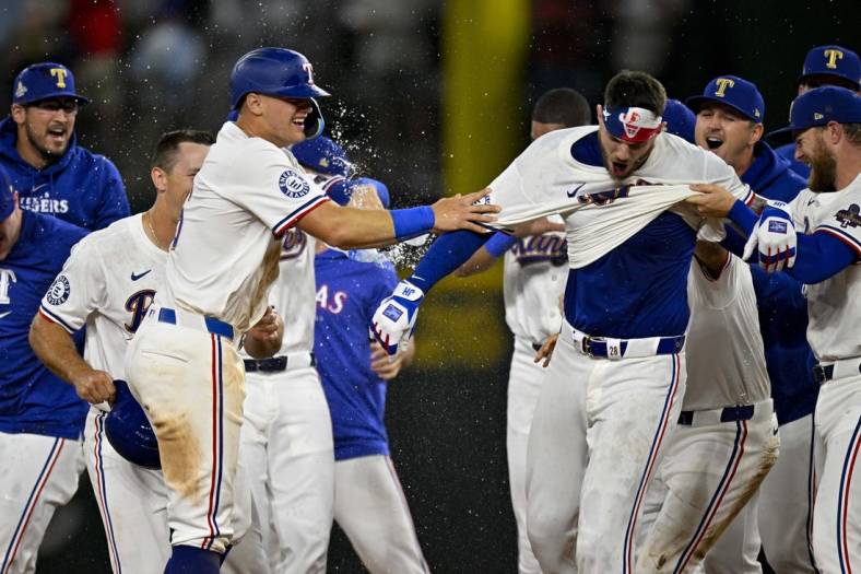 Mar 31, 2024; Arlington, Texas, USA; Texas Rangers catcher Jonah Heim (28) and third baseman Josh Jung (6) celebrate after Heim hits a walk off single against the Chicago Cubs during the tenth inning at Globe Life Field. Mandatory Credit: Jerome Miron-USA TODAY Sports