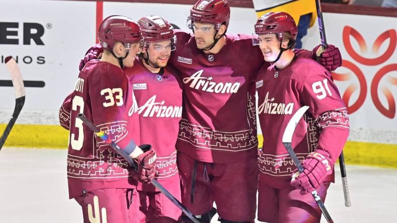 Mar 28, 2024; Tempe, Arizona, USA; Arizona Coyotes center Jack McBain (22) celebrates with right wing Josh Doan (91), left wing Matias Maccelli (63) and defenseman Travis Dermott (33) after scoring a goal in the first period against the Nashville Predators at Mullett Arena. Mandatory Credit: Matt Kartozian-USA TODAY Sports