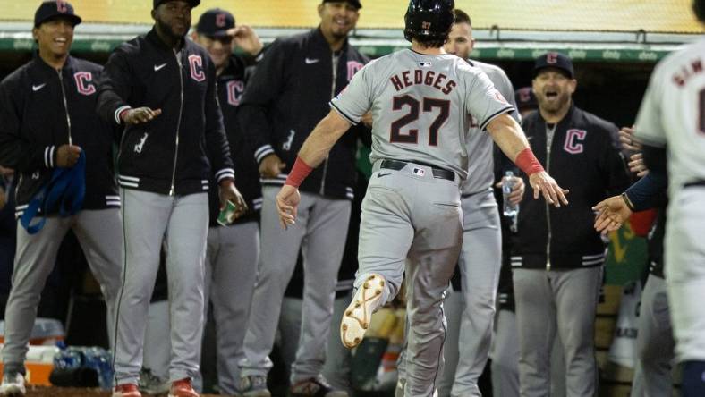 Mar 28, 2024; Oakland, California, USA; Cleveland Guardians catcher Austin Hedges (27) is greeted by his teammates after scoring on a two-RBI double by Brayan Rocchio against the Oakland Athletics during the fourth inning at Oakland-Alameda County Coliseum. Mandatory Credit: D. Ross Cameron-USA TODAY Sports