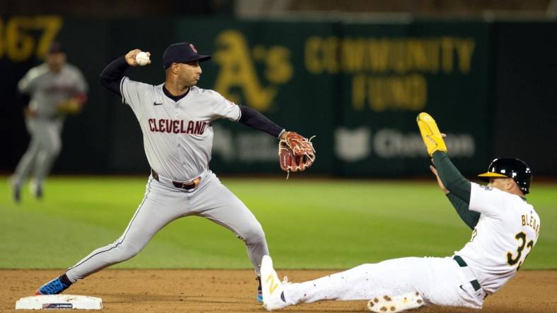 Mar 28, 2024; Oakland, California, USA; Cleveland Guardians shortstop Brayan Rocchio (4) throws over Oakland Athletics center fielder JJ Bleday (33) to complete a double play during the fourth inning at Oakland-Alameda County Coliseum. Seth Brown was out at first base. Mandatory Credit: D. Ross Cameron-USA TODAY Sports