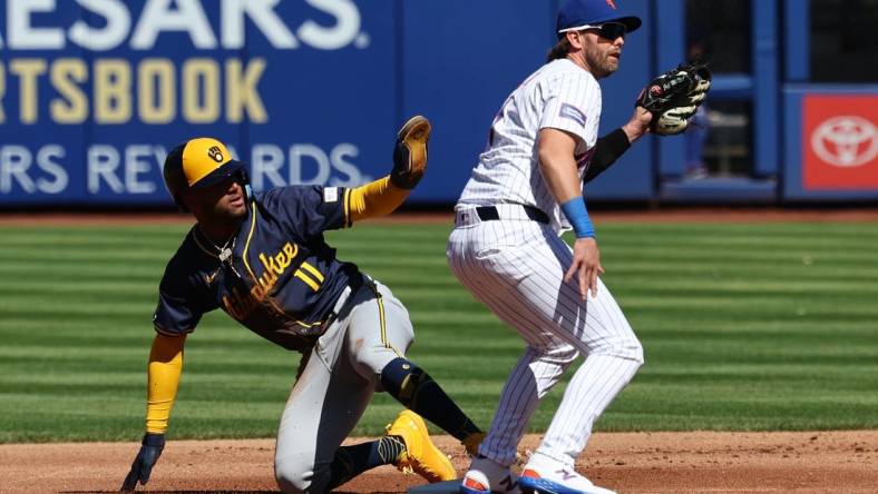 Mar 29, 2024; New York City, New York, USA; Milwaukee Brewers right fielder Jackson Chourio (11) calls for time after stealing second base behind New York Mets second baseman Jeff McNeil (1) before the game at Citi Field. Mandatory Credit: Vincent Carchietta-USA TODAY Sports