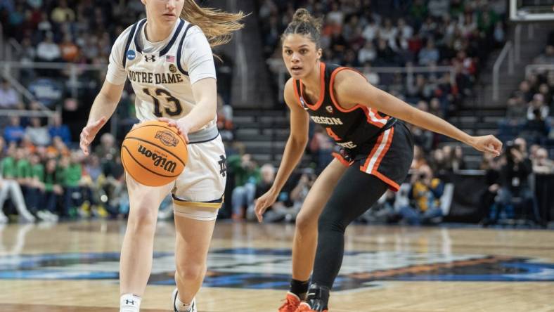 Mar 29, 2024; Albany, NY, USA; Notre Dame Fighting Irish guard Anna DeWolfe (13) dribbles the ball past Oregon State Beavers guard Donovyn Hunter (4) during the first half in the semifinals of the Albany Regional of the 2024 NCAA Tournament at the MVP Arena at MVP Arena. Mandatory Credit: Gregory Fisher-USA TODAY Sports