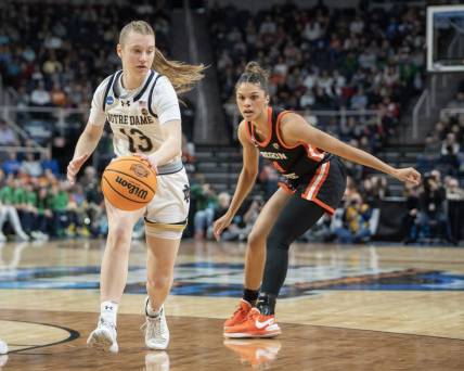 Mar 29, 2024; Albany, NY, USA; Notre Dame Fighting Irish guard Anna DeWolfe (13) dribbles the ball past Oregon State Beavers guard Donovyn Hunter (4) during the first half in the semifinals of the Albany Regional of the 2024 NCAA Tournament at the MVP Arena at MVP Arena. Mandatory Credit: Gregory Fisher-USA TODAY Sports