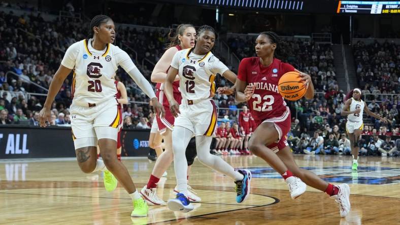 Mar 29, 2024; Albany, NY, USA; Indiana Hoosiers guard Chloe Moore-McNeil (22) drives the ball against South Carolina Gamecocks guard MiLaysia Fulwiley (12) and  forward Sania Feagin (20) during the first half in the semifinals of the Albany Regional of the 2024 NCAA Tournament at the MVP Arena at MVP Arena. Mandatory Credit: Gregory Fisher-USA TODAY Sports