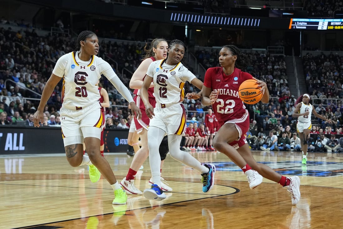 Mar 29, 2024; Albany, NY, USA; Indiana Hoosiers guard Chloe Moore-McNeil (22) drives the ball against South Carolina Gamecocks guard MiLaysia Fulwiley (12) and  forward Sania Feagin (20) during the first half in the semifinals of the Albany Regional of the 2024 NCAA Tournament at the MVP Arena at MVP Arena. Mandatory Credit: Gregory Fisher-USA TODAY Sports